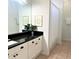 Bathroom with a black granite countertop, white cabinets, and artwork for a contemporary aesthetic at 8023 King Palm Cir, Kissimmee, FL 34747