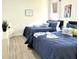 A bedroom showcases two twin beds with navy bedding, complemented by wood-look flooring and soft natural light at 8023 King Palm Cir, Kissimmee, FL 34747