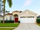 Charming single-Gathering home with a red door, manicured lawn, and a two-car garage at 8023 King Palm Cir, Kissimmee, FL 34747