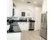 Modern kitchen with black countertops, white cabinets, and stainless steel appliances at 8023 King Palm Cir, Kissimmee, FL 34747