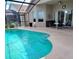Inviting screened-in pool area with clean water and modern fixtures, next to a covered patio with a bar at 8023 King Palm Cir, Kissimmee, FL 34747