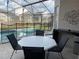 Screened-in pool area with an outdoor dining table and a view of the backyard at 8023 King Palm Cir, Kissimmee, FL 34747
