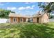 View of a spacious backyard with a green lawn and decorative tilework, patio and a large shade tree at 836 Copperfield Ter, Casselberry, FL 32707