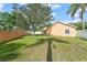 Spacious fenced backyard featuring a lush green lawn with a large tree providing shade and a screen enclosed patio at 836 Copperfield Ter, Casselberry, FL 32707