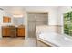 Relaxing bathroom with a soaking tub, separate glass enclosed shower and vanity with decorative chair at 836 Copperfield Ter, Casselberry, FL 32707
