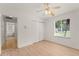 Bright bedroom featuring a light wood floor, white walls, a window, and a closet with a colorful ceiling fan at 836 Copperfield Ter, Casselberry, FL 32707