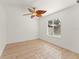 Bright bedroom featuring a light wood floor, white walls, and a window with a unique leaf-shaped ceiling fan at 836 Copperfield Ter, Casselberry, FL 32707