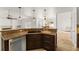 Open kitchen with breakfast bar, granite countertops, dark cabinets and stainless steel dishwasher at 836 Copperfield Ter, Casselberry, FL 32707