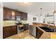 Well-equipped kitchen featuring stainless steel appliances, granite countertops, and dark wood cabinetry at 836 Copperfield Ter, Casselberry, FL 32707