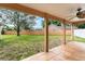 Covered patio area with decorative tilework, looking out onto a spacious fenced backyard and green lawn at 836 Copperfield Ter, Casselberry, FL 32707