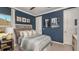 Cozy bedroom with blue walls, decorative wall art, and a comfortable bed with patterned pillows at 853 Junonia Blvd, New Smyrna Beach, FL 32168