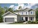 Charming two-story home showcasing a covered entry, neutral color palette, and a well-maintained lawn at 853 Junonia Blvd, New Smyrna Beach, FL 32168