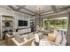 Stylish living room with coffered ceilings, comfortable seating, and a view of the pool area at 853 Junonia Blvd, New Smyrna Beach, FL 32168