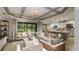 Open-concept living room and kitchen area with coffered ceilings and sliding glass door to outdoor space at 853 Junonia Blvd, New Smyrna Beach, FL 32168