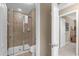 Bathroom featuring a glass-enclosed shower, neutral tile, and an adjacent doorway at 8972 Coco Palm Rd, Kissimmee, FL 34747