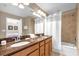 Bathroom with double sinks, a shower tub combo and wood cabinets at 8972 Coco Palm Rd, Kissimmee, FL 34747