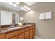 Bathroom featuring dual sinks, a large mirror, updated lighting, and a neutral color palette at 8972 Coco Palm Rd, Kissimmee, FL 34747