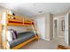 Bedroom with a wooden bunk bed, closet, and doorway with cozy blue and red accents at 8972 Coco Palm Rd, Kissimmee, FL 34747