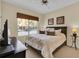 Bedroom with large window, ceiling fan, neutral carpet and ensuite bathroom at 8972 Coco Palm Rd, Kissimmee, FL 34747