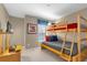 Bedroom with a wooden bunk bed, window with blinds, TV, and cozy blue and red accents at 8972 Coco Palm Rd, Kissimmee, FL 34747