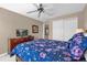 A well-lit bedroom features neutral walls, a ceiling fan, and a cozy floral-patterned bedspread at 8972 Coco Palm Rd, Kissimmee, FL 34747
