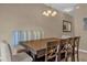 Charming dining area with ample seating, a modern chandelier, and neutral decor at 8972 Coco Palm Rd, Kissimmee, FL 34747