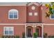 Multi-Gathering home featuring a red facade, arched entryways and manicured landscaping at 8972 Coco Palm Rd, Kissimmee, FL 34747