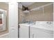 Functional laundry room with a washer, dryer, storage shelves, and space-saving ironing board at 8972 Coco Palm Rd, Kissimmee, FL 34747
