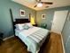 Cozy bedroom with hardwood floors, ceiling fan, and a comfortable queen-sized bed at 913 Red Fox Rd, Altamonte Springs, FL 32714