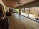 Spacious sunroom with travertine flooring, ceiling fans, and sliding glass doors to the private backyard at 913 Red Fox Rd, Altamonte Springs, FL 32714