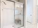 Bright bathroom featuring a walk-in shower with a glass door and a convenient shower seat at 9432 Komika Ln, Winter Garden, FL 34787