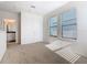 Bright bedroom featuring carpet flooring, neutral walls, and a door to the en suite bathroom at 9432 Komika Ln, Winter Garden, FL 34787