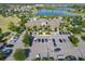 An aerial view of the clubhouse with palm trees, landscaping, and parking at 9432 Komika Ln, Winter Garden, FL 34787