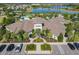 Aerial view of the clubhouse featuring decorative landscaping, parking spaces, and a welcoming entrance at 9432 Komika Ln, Winter Garden, FL 34787