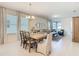 Dining area with hardwood floors adjacent to a living room with large windows and neutral decor at 9432 Komika Ln, Winter Garden, FL 34787