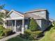 Well-maintained home features lush landscaping, a covered front porch, and a charming exterior at 9432 Komika Ln, Winter Garden, FL 34787
