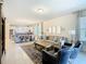 Bright living space with an open floor plan, tile flooring, modern decor, and a seamless flow to the kitchen at 9432 Komika Ln, Winter Garden, FL 34787