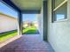 Covered patio with brick pavers and a view of the manicured lawn and neighboring houses at 9432 Komika Ln, Winter Garden, FL 34787