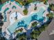 Overhead image of a large community pool, palm trees, lounge chairs, and shaded areas for relaxation at 9432 Komika Ln, Winter Garden, FL 34787