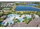 An aerial view of the community pool and amenities surrounded by palm trees, lounge chairs, and lake views at 9432 Komika Ln, Winter Garden, FL 34787