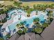 An aerial shot of the modern, resort-style pool showcasing palm trees, lounge seating, and community gathering spaces at 9432 Komika Ln, Winter Garden, FL 34787