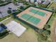 Aerial view showcasing well-maintained tennis and sand volleyball courts perfect for recreation at 9432 Komika Ln, Winter Garden, FL 34787