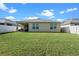 Spacious backyard with green lawn, privacy fence, and covered patio at 1059 Cypress Fox Blvd, Davenport, FL 33897