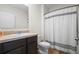 Well-lit bathroom featuring a classic vanity with a sink, toilet, and a shower with a stylish shower curtain at 1059 Cypress Fox Blvd, Davenport, FL 33897
