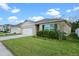 Beautiful single-Gathering home with a neat front lawn, blue shutters and a convenient two-car garage at 1059 Cypress Fox Blvd, Davenport, FL 33897