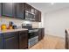 This kitchen has stainless steel appliances, dark cabinets and tile floor at 1059 Cypress Fox Blvd, Davenport, FL 33897