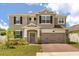 Charming two-story home featuring stone accents, a two-car garage, and a brick-paved driveway at 1118 Franklin Tree Ln, Sanford, FL 32771