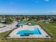 Aerial view of community pool with lifeguard stands and splashpad in Gathering-friendly recreation area with lawn and picnic at 1211 Normandy Dr, Haines City, FL 33844