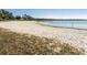 Sandy beach area with views of the serene lake and clear blue skies at 1211 Normandy Dr, Haines City, FL 33844