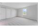 Bright bedroom featuring a window overlooking the pond, carpet flooring, and ample closet space for optimal storage at 1211 Normandy Dr, Haines City, FL 33844